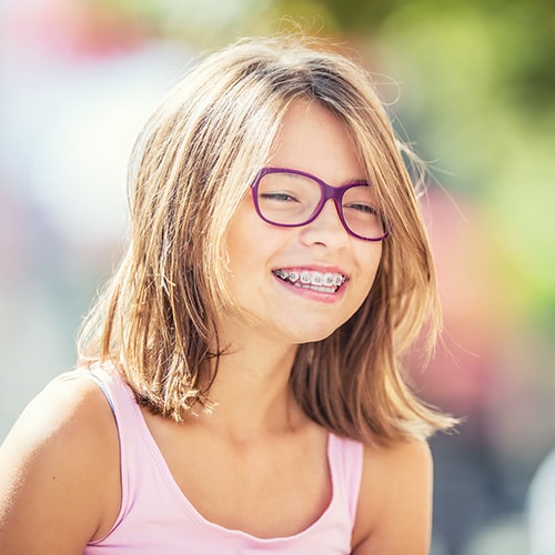 Little girl smiling with braces at Ossa Orthodontics in Caldwell, OH